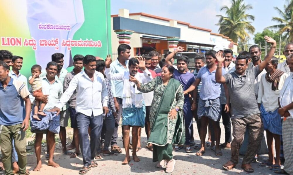 Residents of Siddaramanahundi celebrate outside Siddaramaiah house